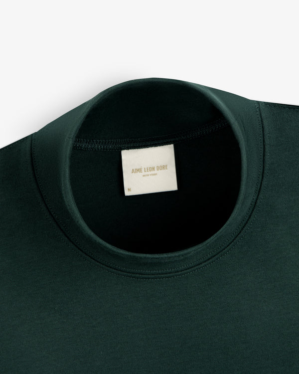 Dark green Heavyweight Crest Mockneck Tee with an interior Aimé Leon Dore, New York brand label.