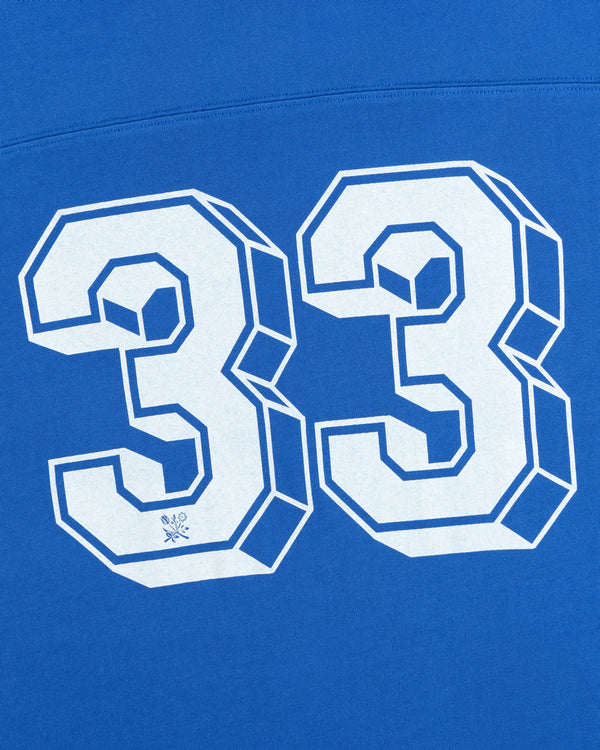 White 3D block lettering of the number 33 on a bright blue Football Ringer Tee.