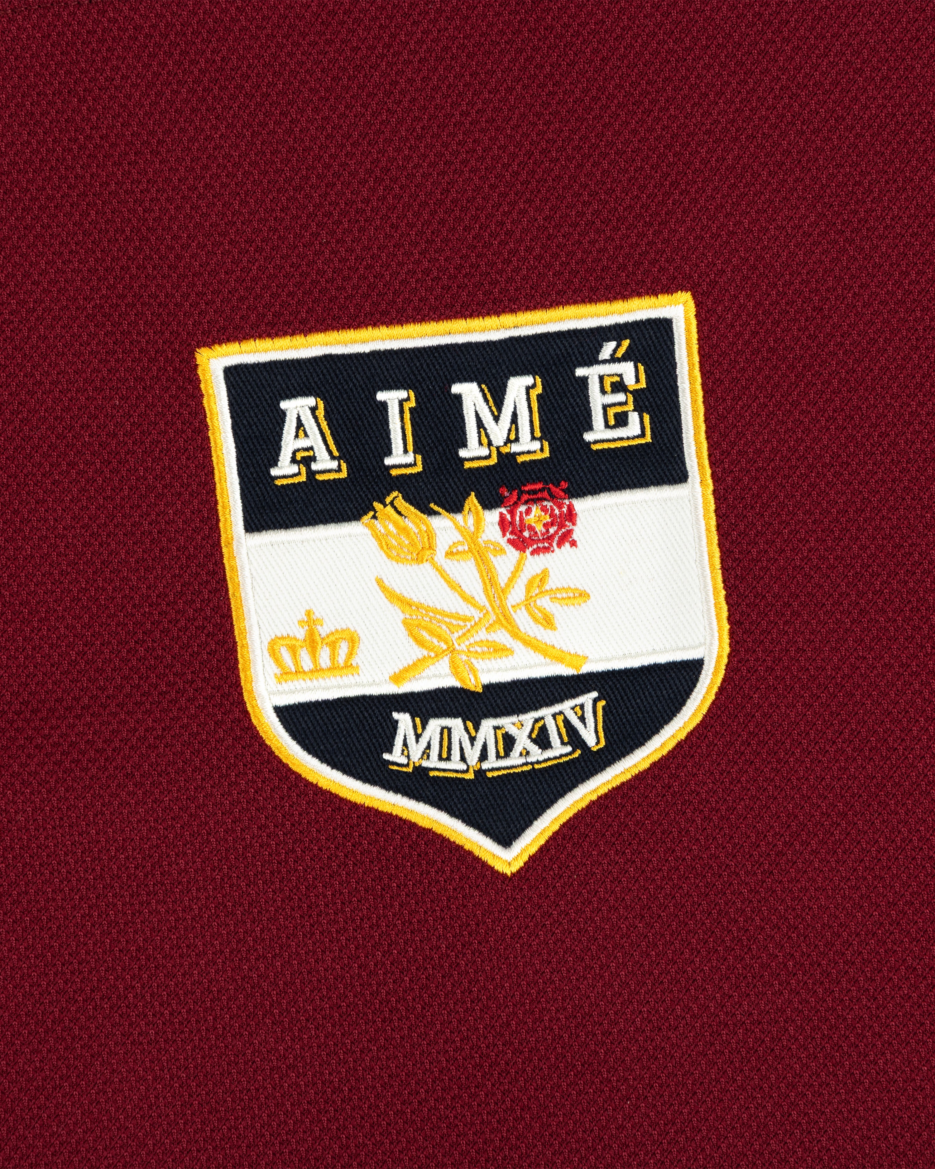 Team Aimé Hockey Jersey featuring an embroidered maroon shield patch with the text AIME, a flower, a crown, and MMXIV.