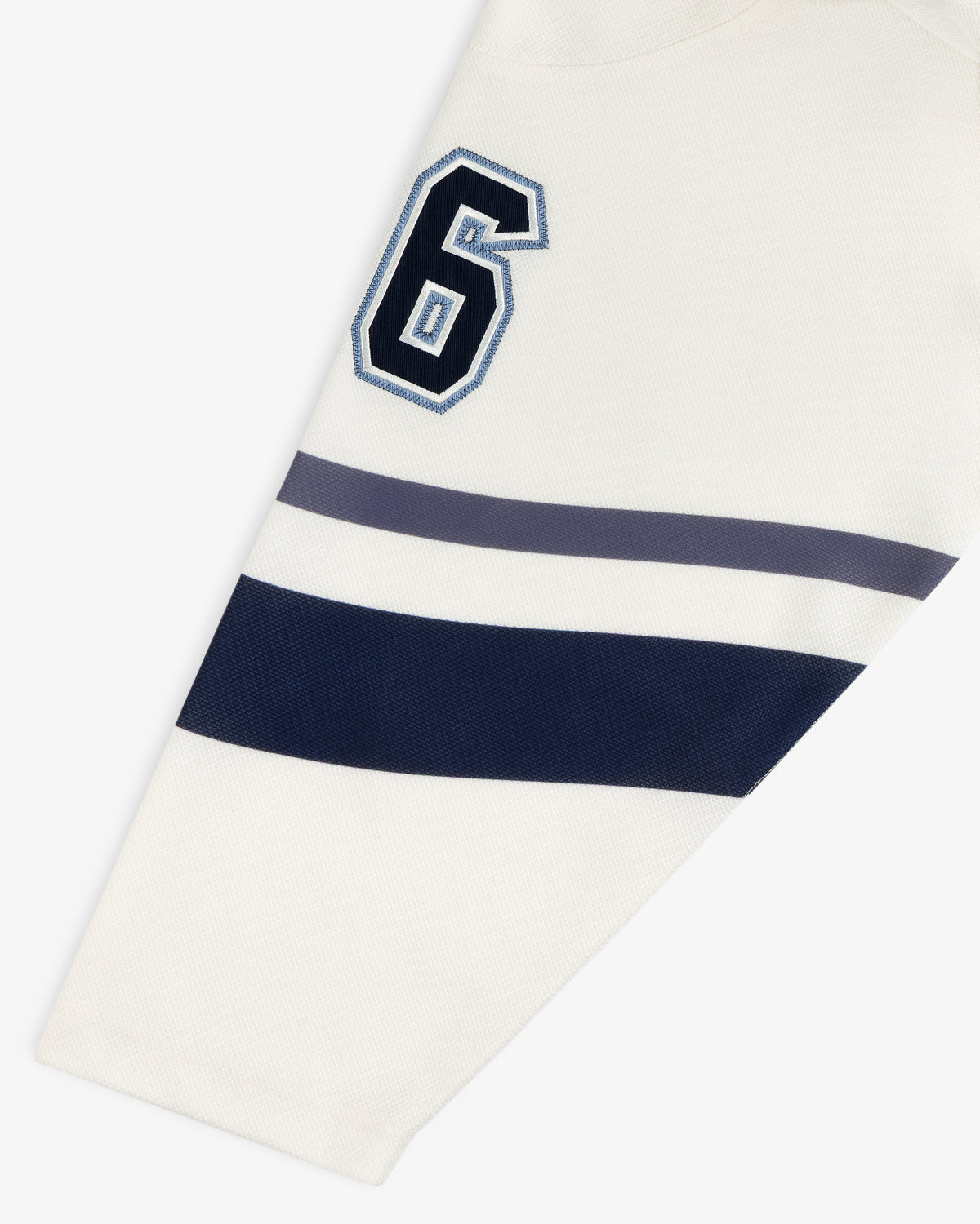 Team Aimé Hockey Jersey sleeve in cream featuring a navy and white number 6 with navy and gray horizontal stripes.