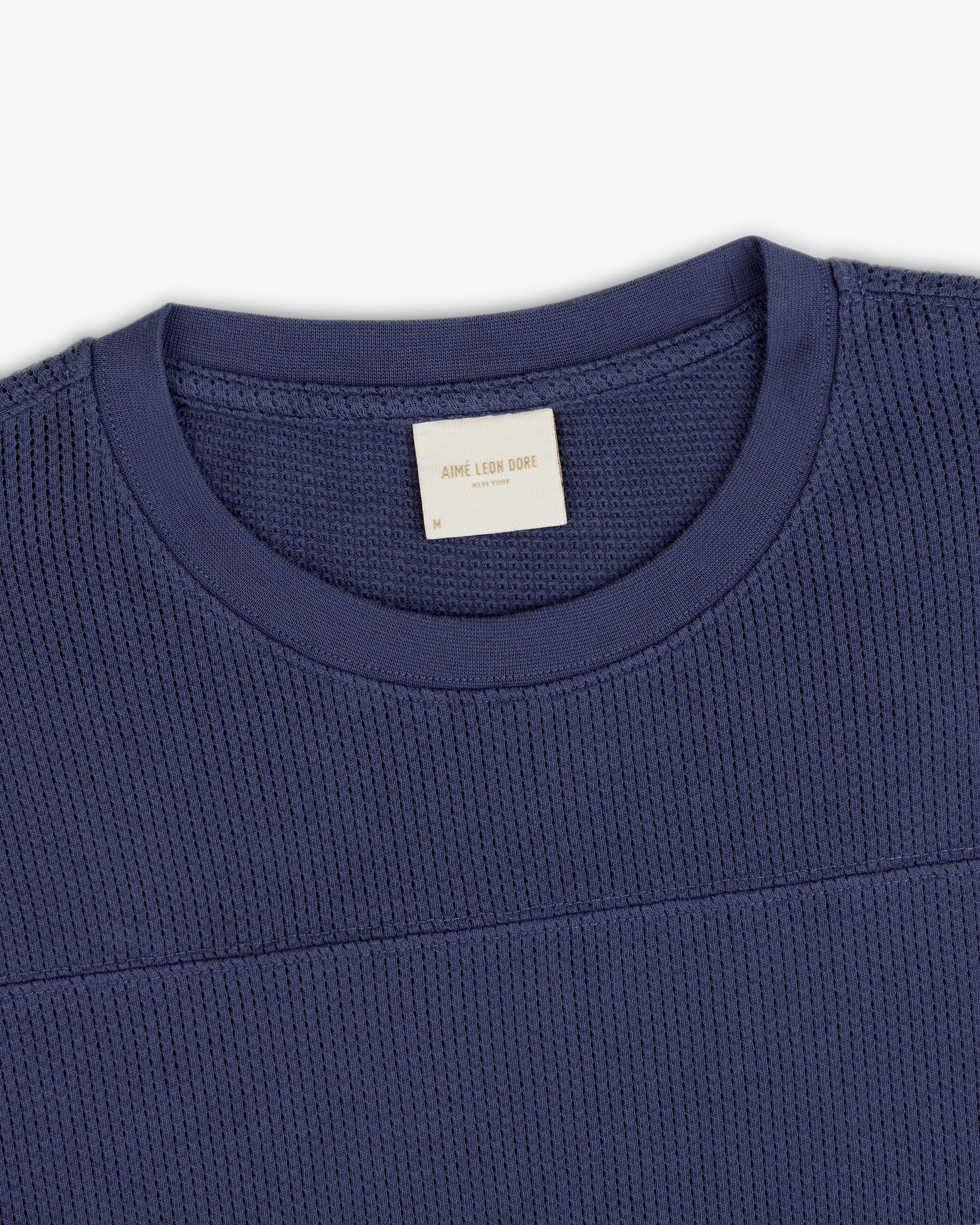Navy blue Long-Sleeve Mesh Football Tee with visible Aimé Leon Dore collar label, on a white background.