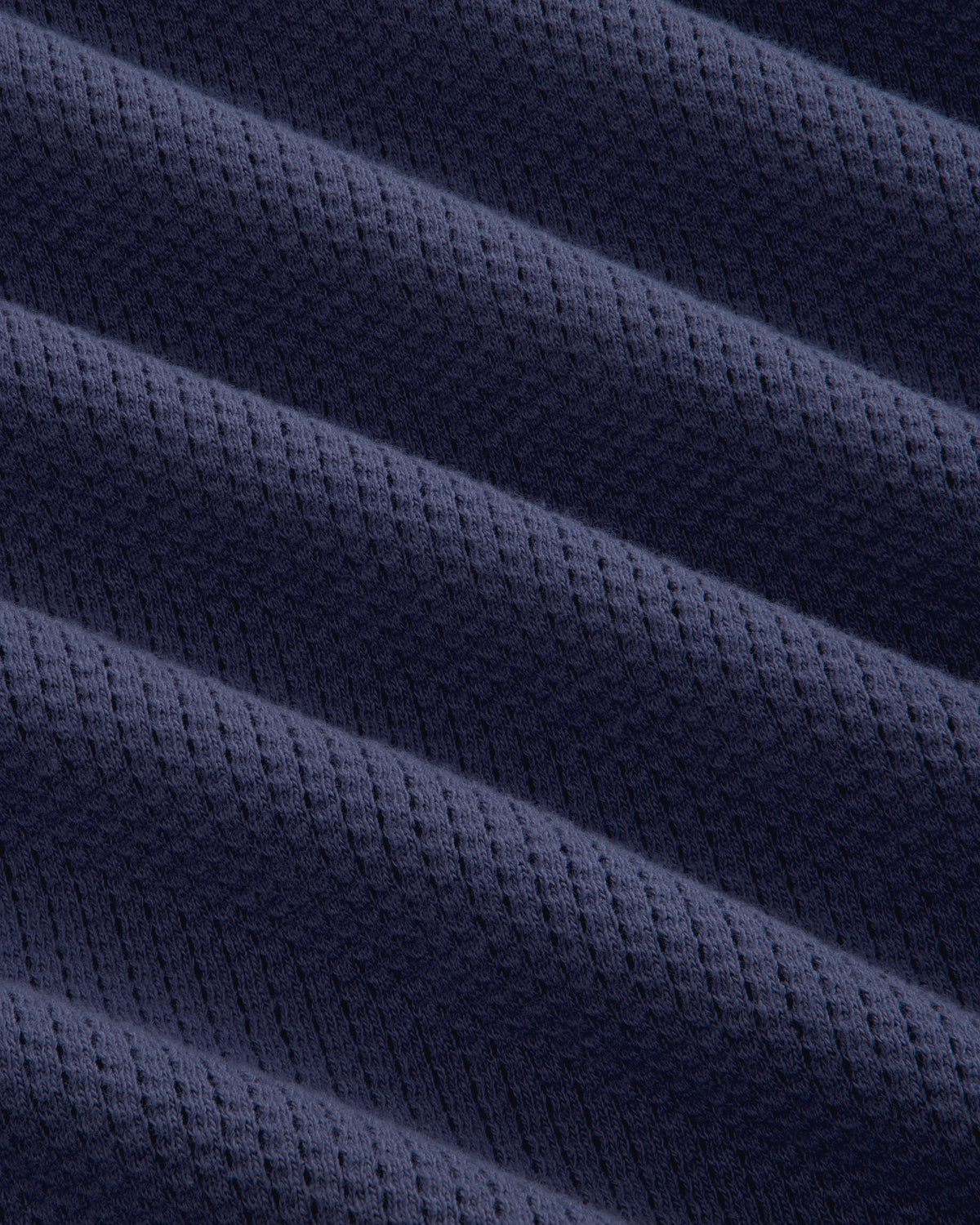 Close-up of Long-Sleeve Mesh Football Tee in dark blue, featuring diagonal ridges and a dotted texture.