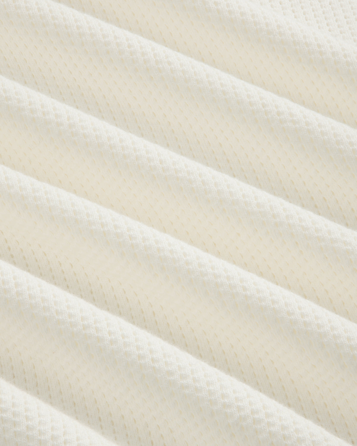 Close-up of Long-Sleeve Mesh Football Tee’s white, textured fabric with diagonal ridges and diamond pattern.