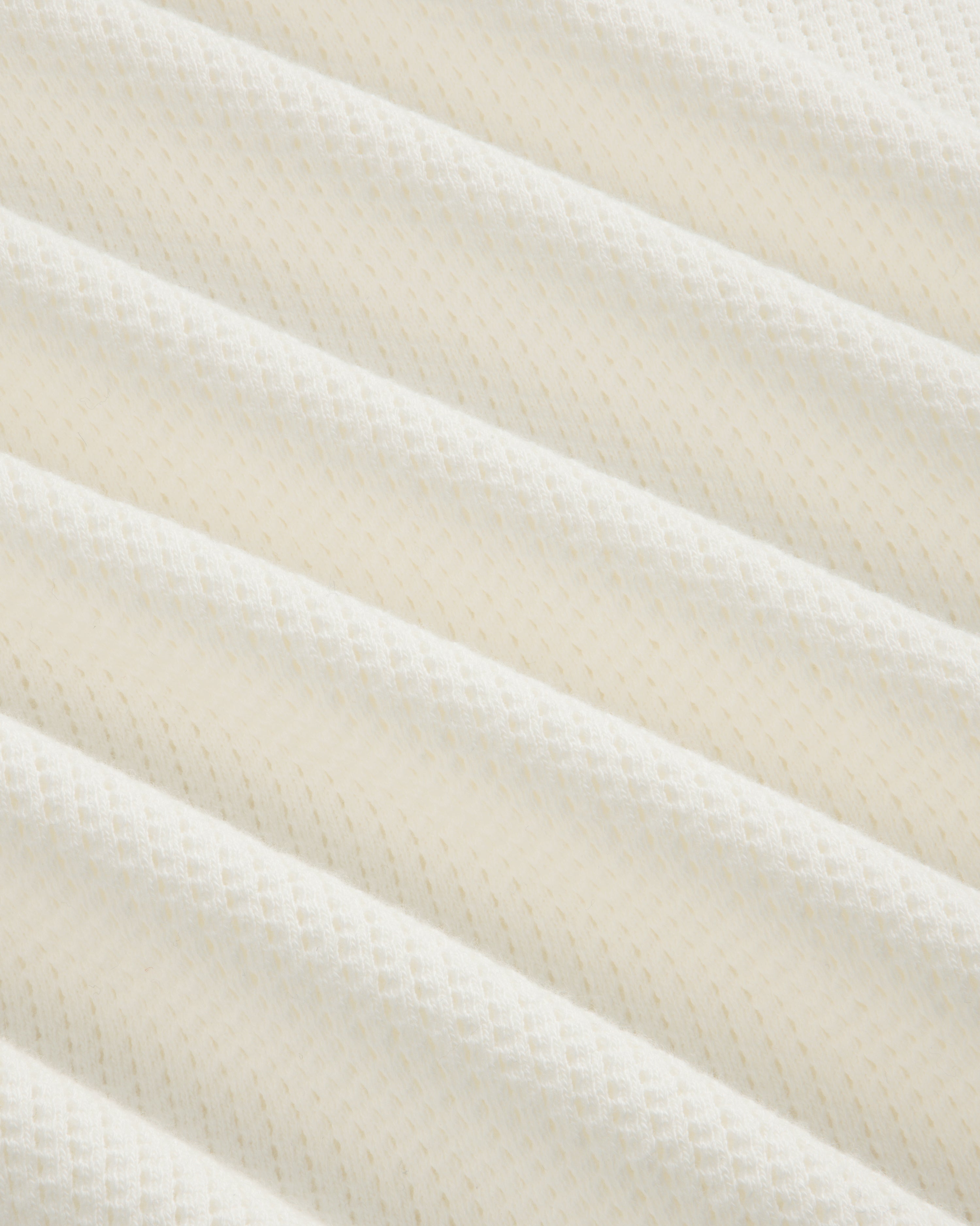 Close-up of Long-Sleeve Mesh Football Tee’s white, textured fabric with diagonal ridges and diamond pattern.