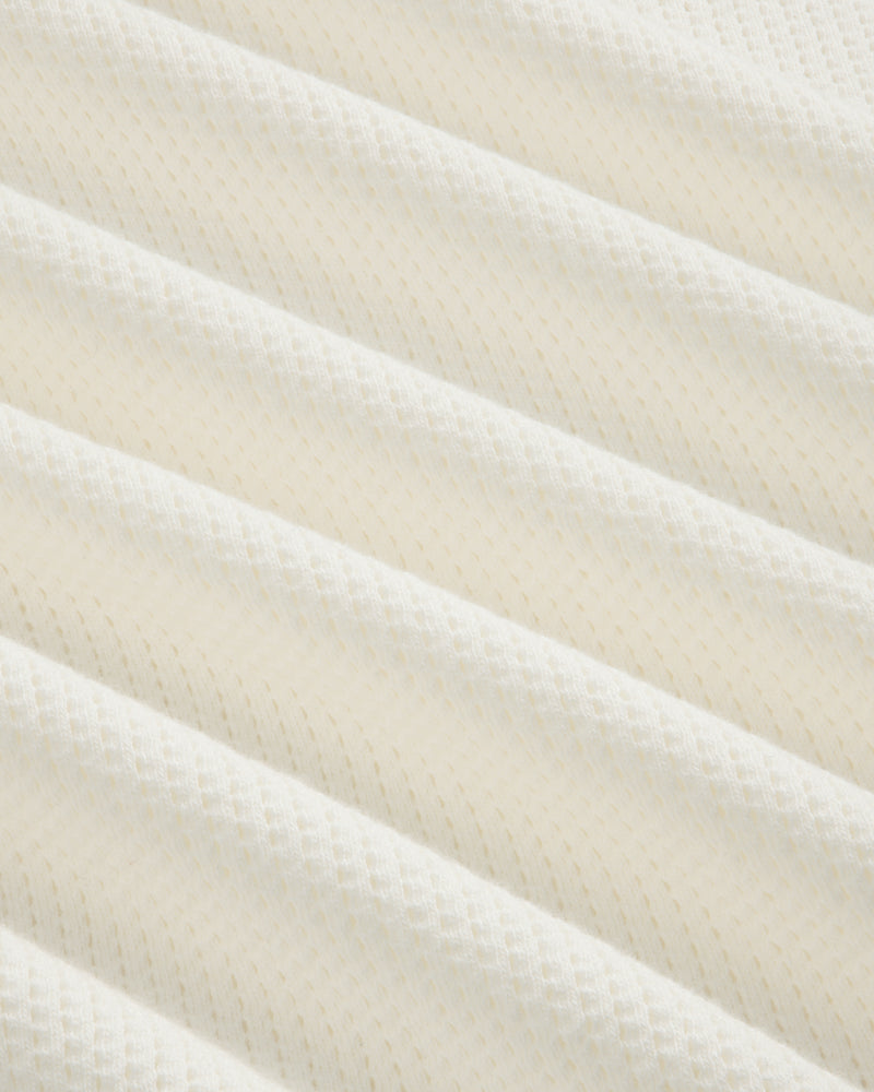 Close-up of Long-Sleeve Mesh Football Tee’s white, textured fabric with diagonal ridges and diamond pattern.