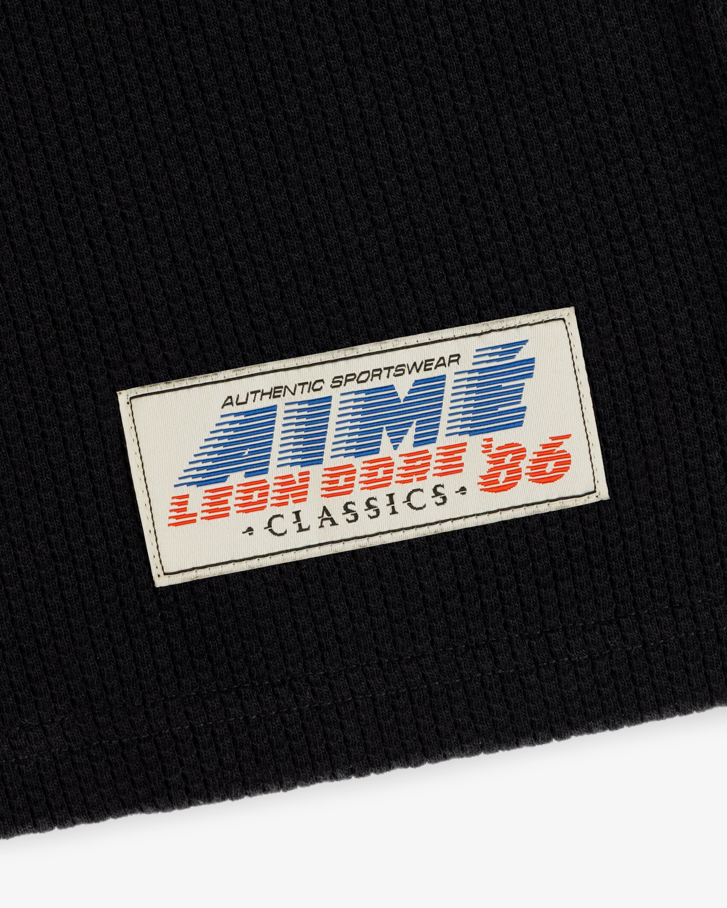 The Long-Sleeve Mesh Football Tee features a white patch on black with ATMS 3, LEON DORE 86, and CLASSICS text.