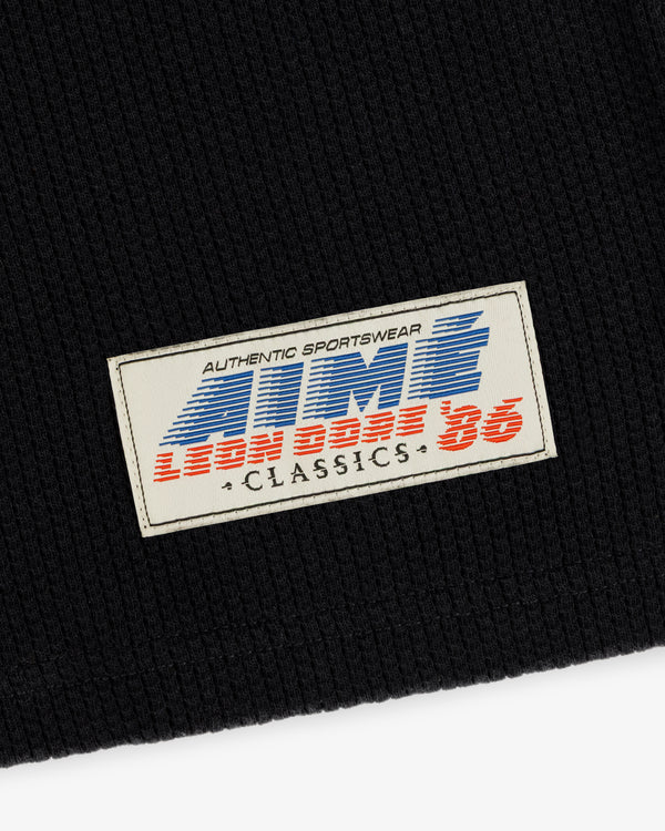 The Long-Sleeve Mesh Football Tee features a white patch on black with ATMS 3, LEON DORE 86, and CLASSICS text.
