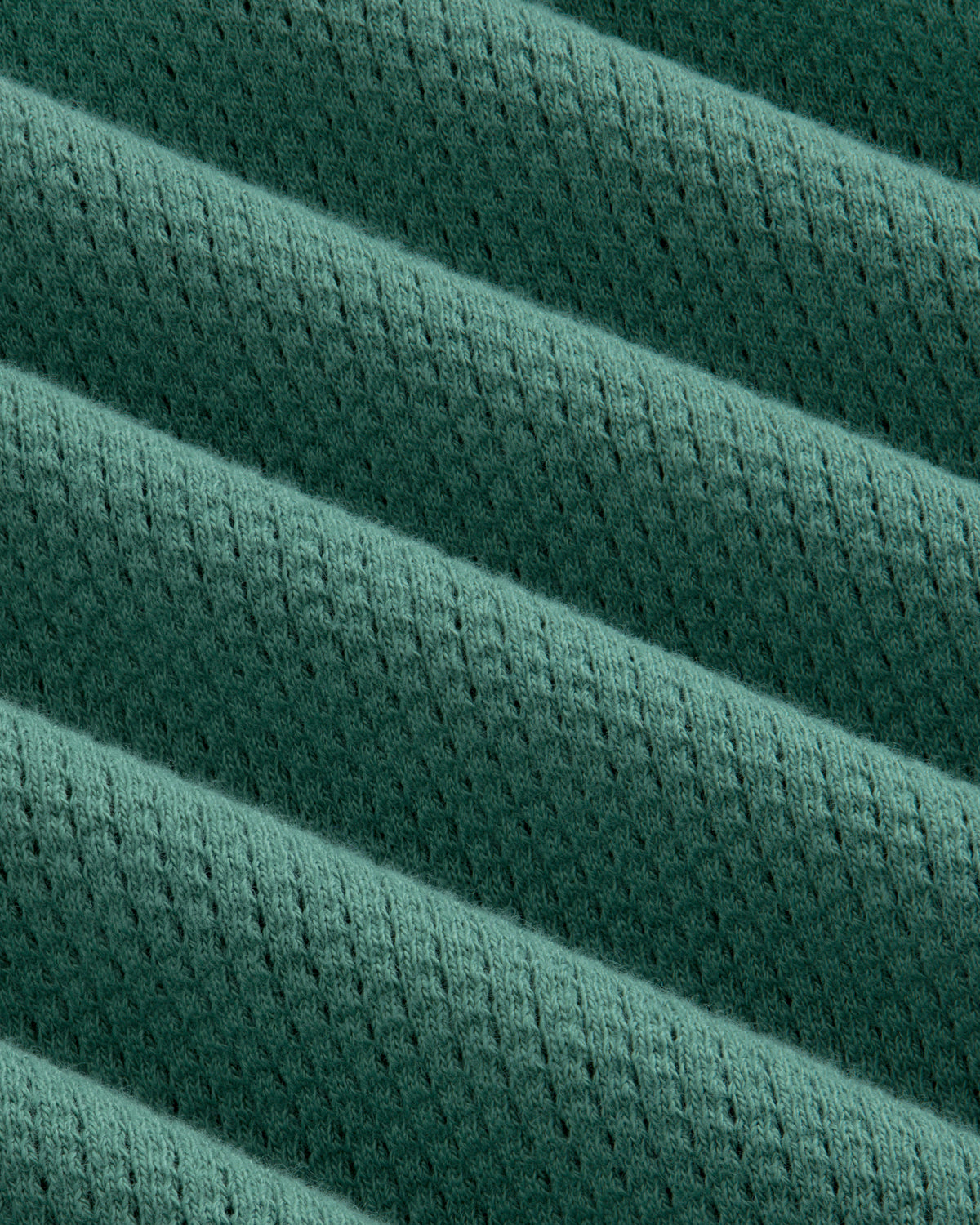 Close-up of the Long-Sleeve Mesh Football Tee’s green ribbed fabric with diagonal ridges and perforations.