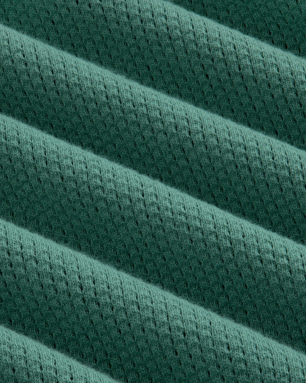Close-up of the Long-Sleeve Mesh Football Tee’s green ribbed fabric with diagonal ridges and perforations.
