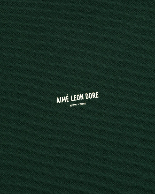 Dark green Micro Logo Tee with small white “Aimé Leon Dore New York” text in the center.