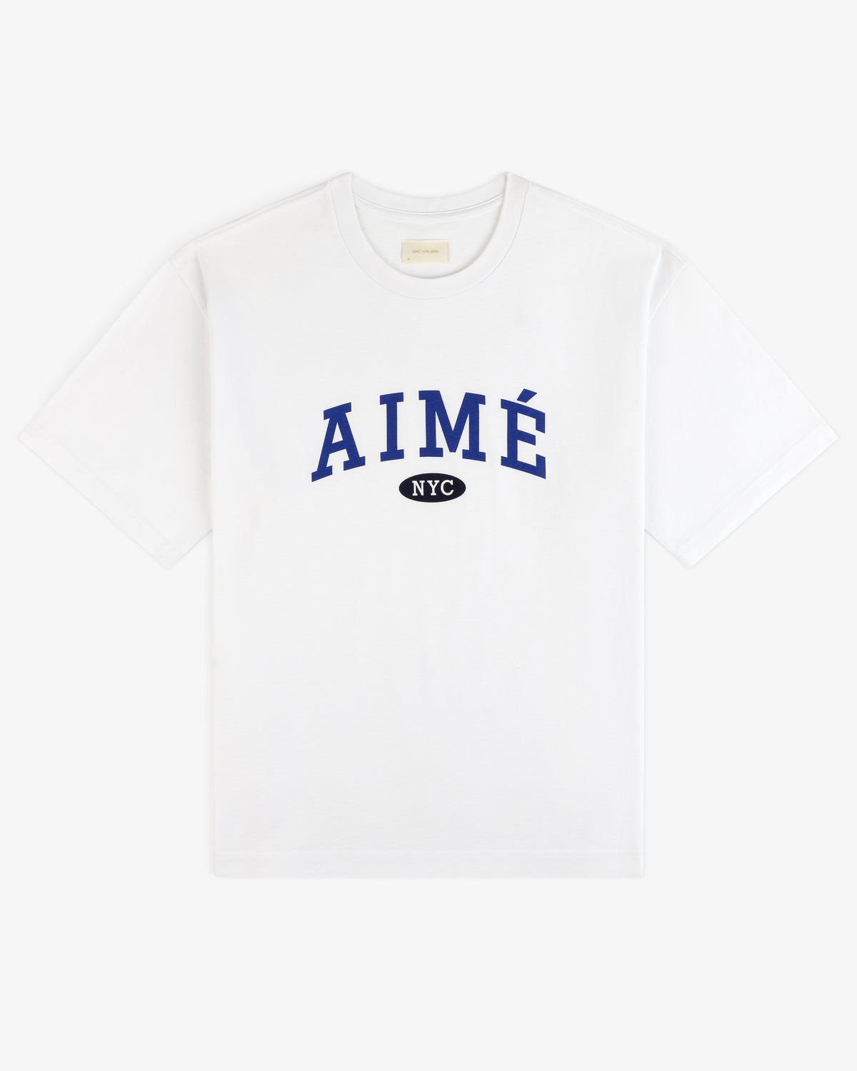 Aimé Souvenir Tee: White tee with blue AIMÉ lettering, black NYC oval below, centered on the chest.