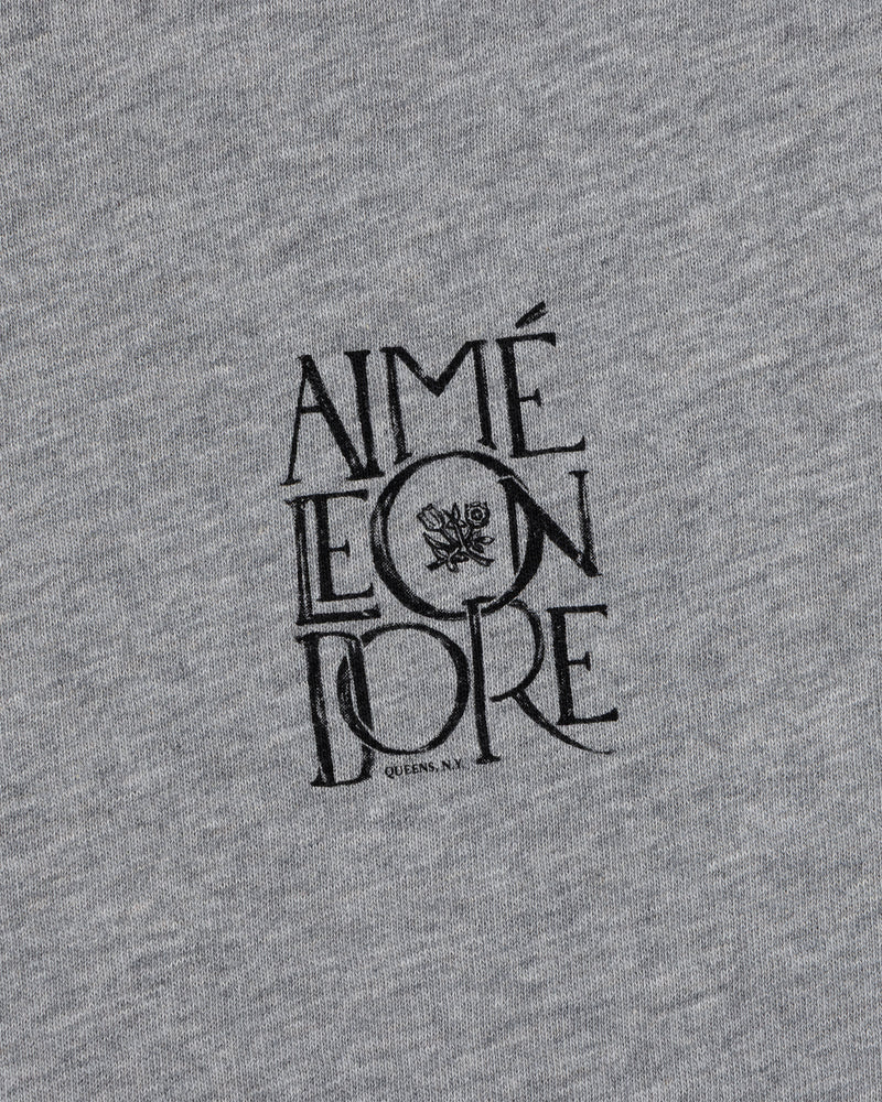 Gray Stacked Logo Slub Tee by Aimé Leon Dore with a small black floral graphic, centered on the fabric.