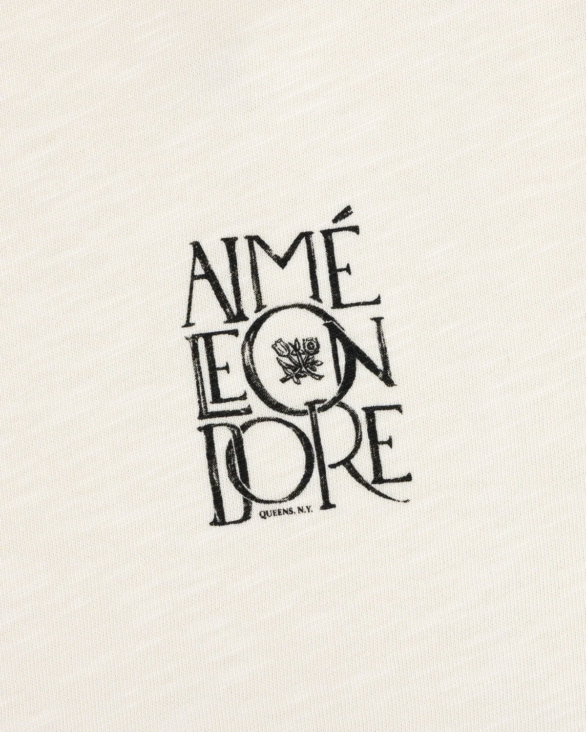 Stacked Logo Slub Tee: Off-white slub with black AIMÉ LEON DORE text and a small rose graphic.