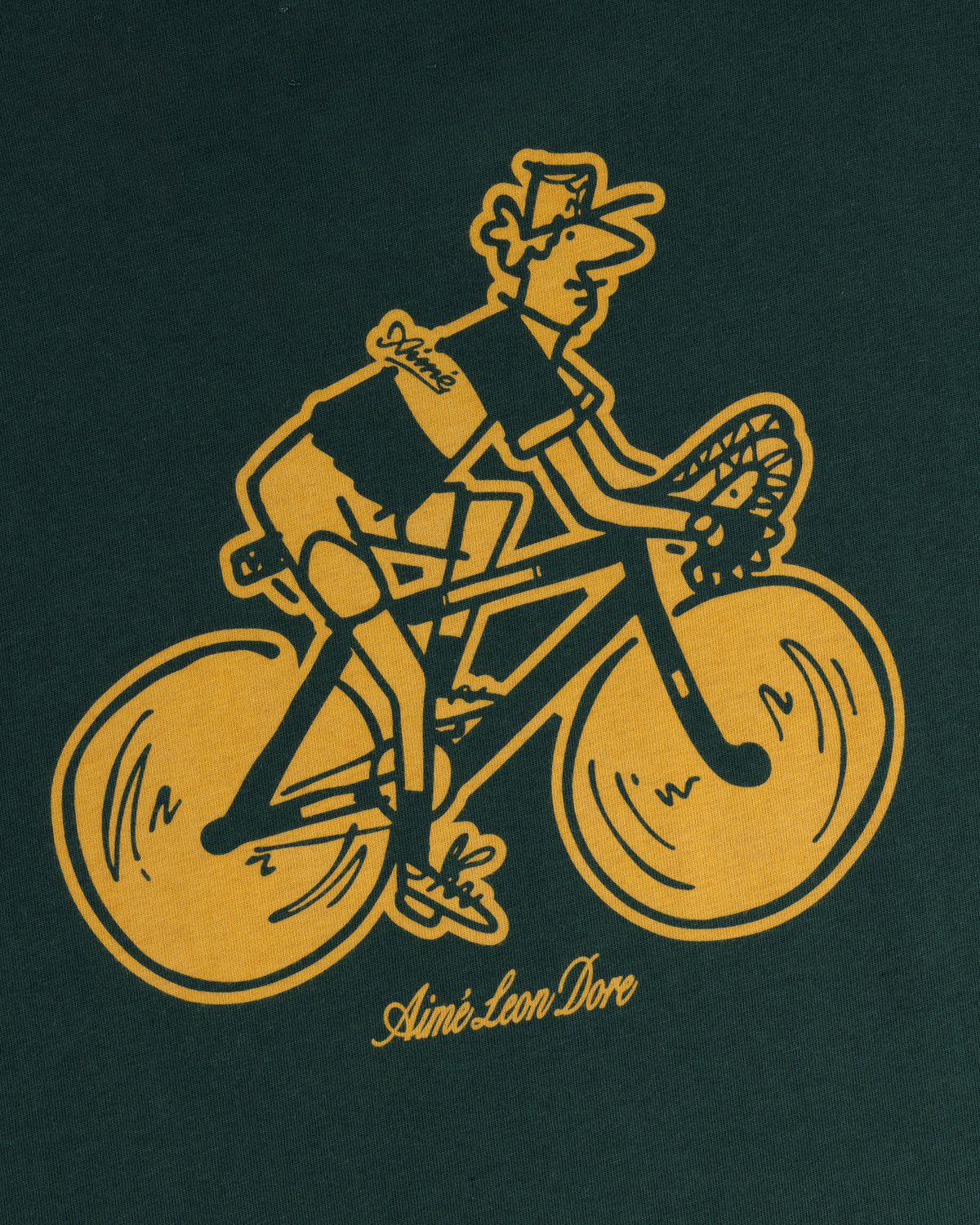 Aimé Tour Graphic Tee with yellow cyclist delivering bread on dark green, Aimé Leon Dore text below.