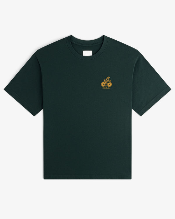 Aimé Tour Graphic Tee in dark green with a small yellow graphic and text on the left chest.