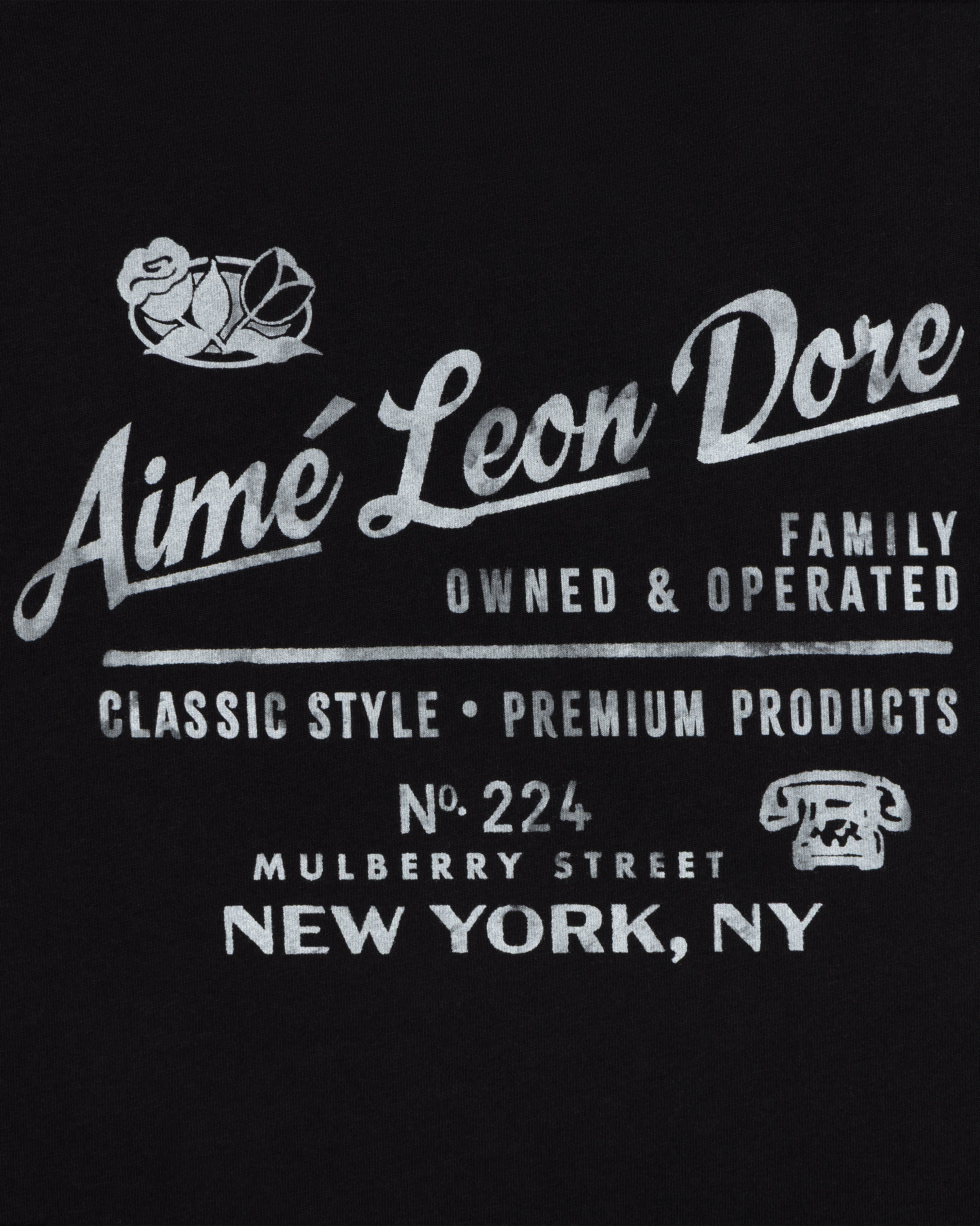 White text on black: Neighborhood Tee by Aimé Leon Dore, 224 Mulberry St, NY. Classic style. Rose & phone icon.