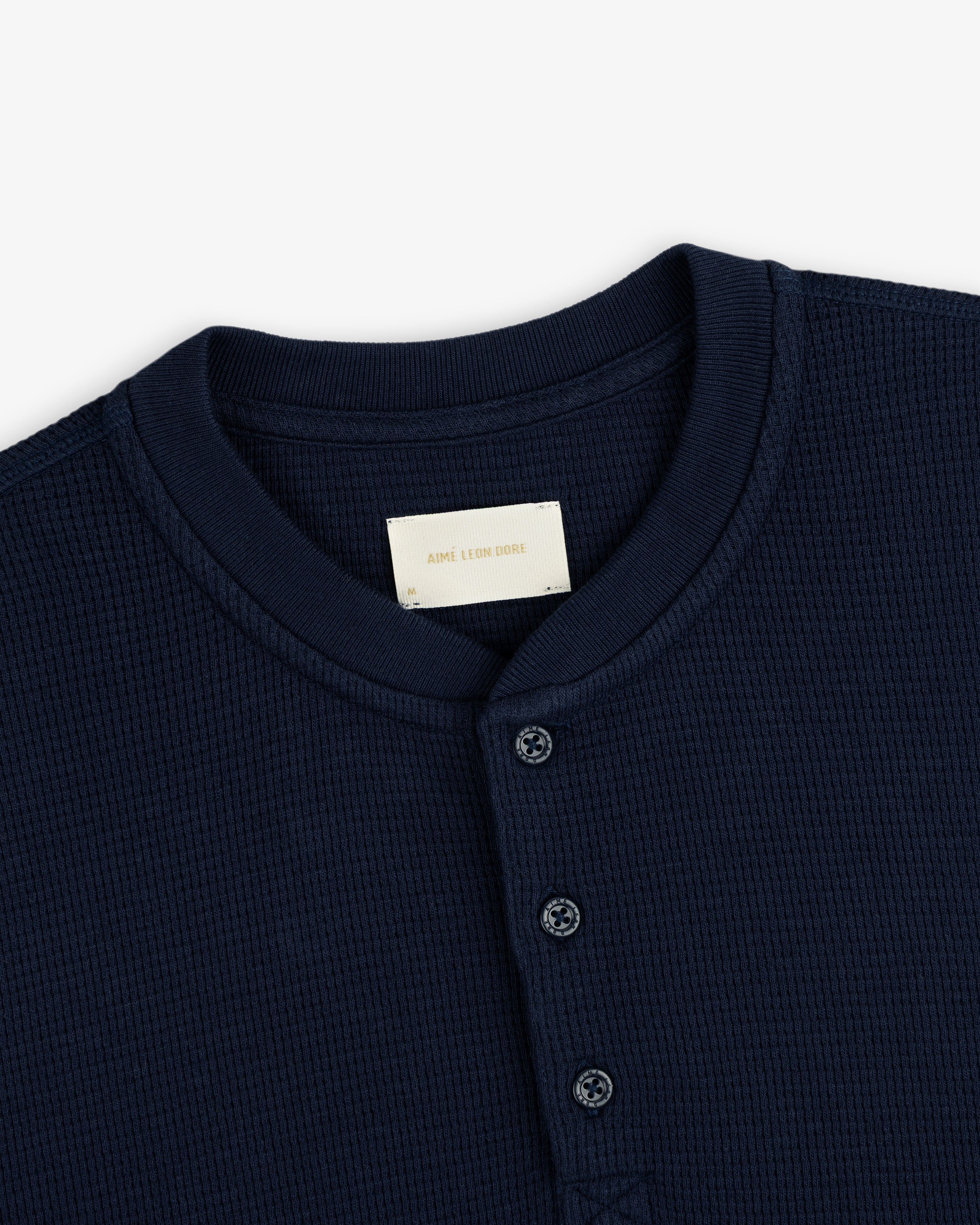 Navy blue Long-Sleeve Waffle Henley with a button placket and collar tag.
