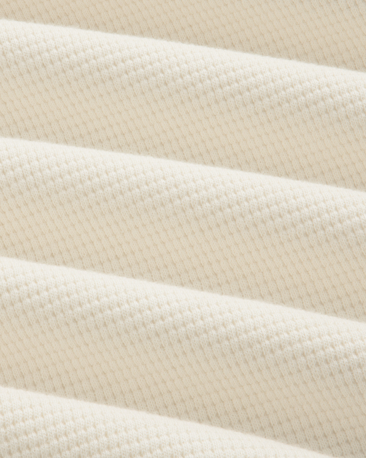 Close-up of the off-white Long-Sleeve Waffle Henley in a textured waffle-knit pattern.