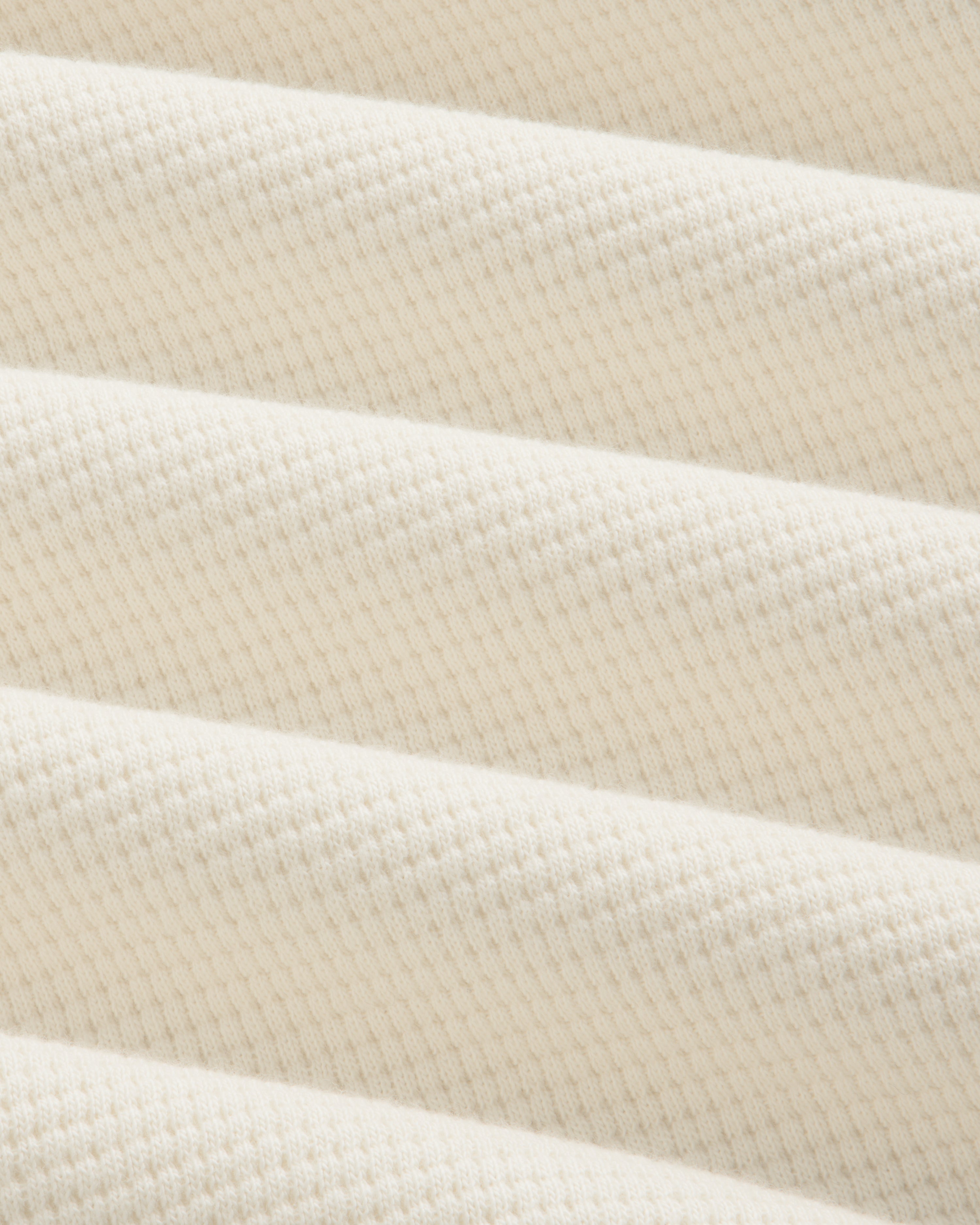 Close-up of the off-white Long-Sleeve Waffle Henley in a textured waffle-knit pattern.