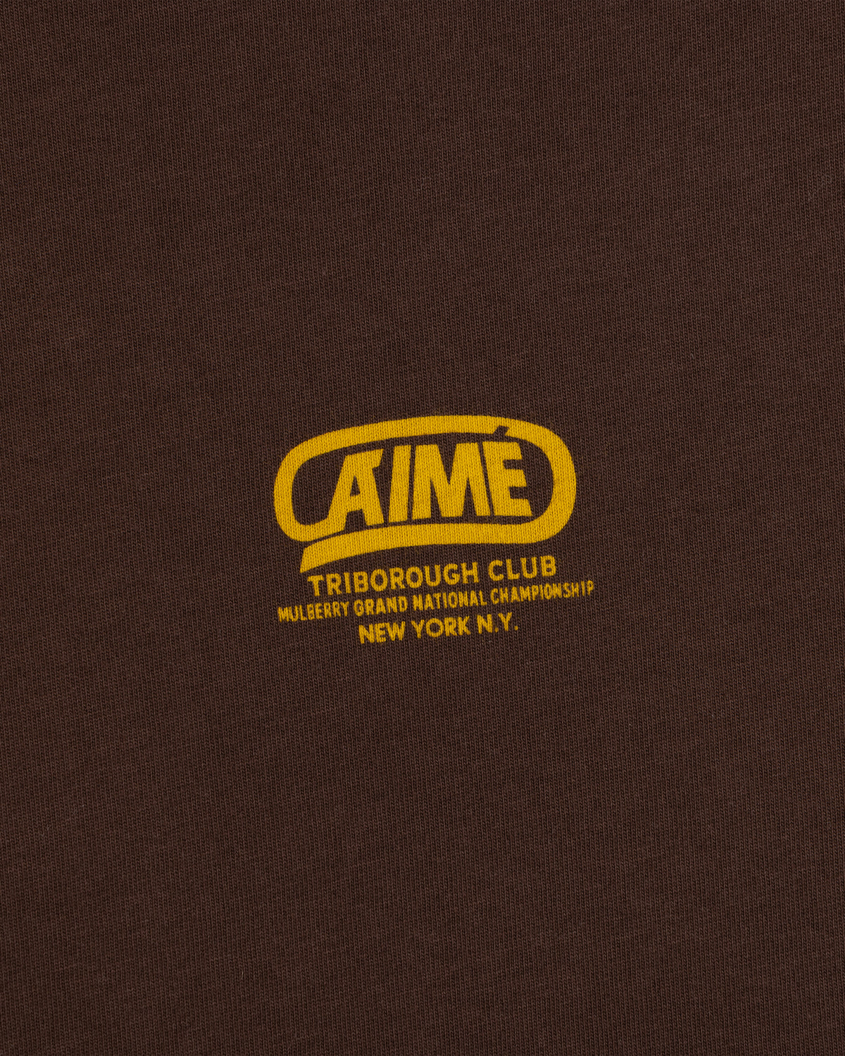 Dark brown Triborough Club Tee with a yellow logo reading Aimé, Triborough Club, and Mulberry Grand National Championship.