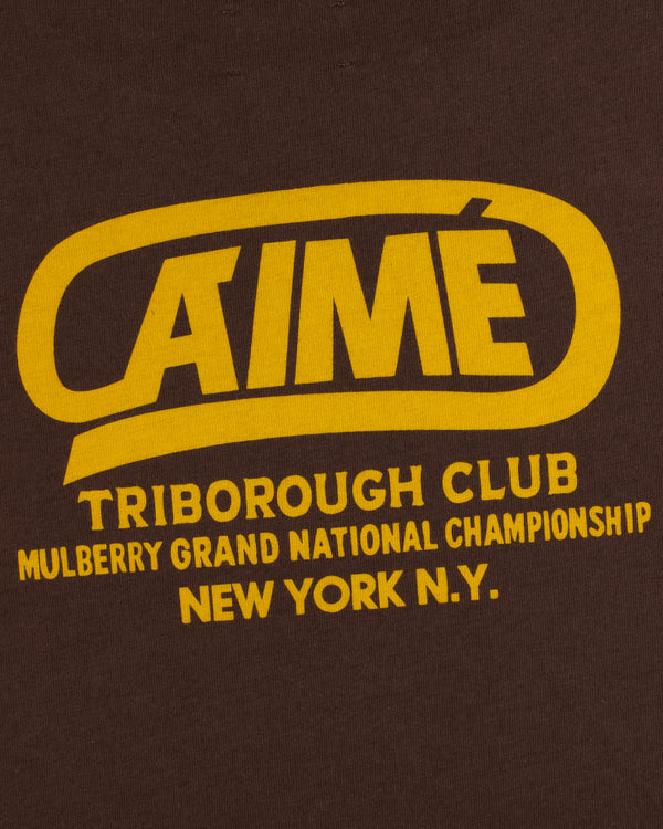 Dark brown Triborough Club Tee with yellow text reading Aimé Triborough Club Mulberry Grand National Championship New York.