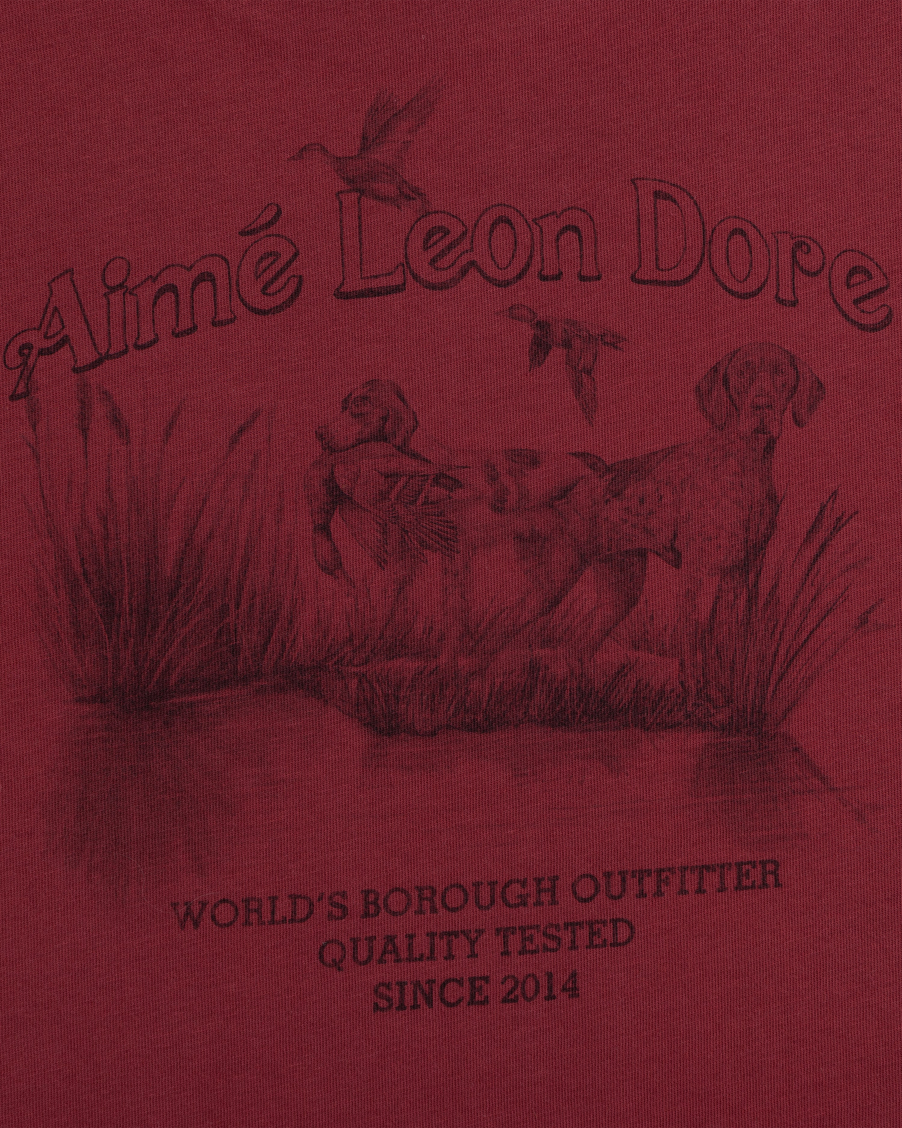 Dark red Long-Sleeve Retriever Tee featuring a graphic of two dogs in tall grass, flying ducks, and Aimé Leon Dore text.