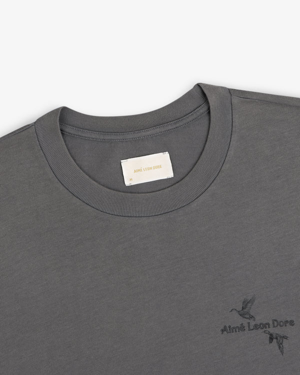 Grey Long-Sleeve Retriever Tee with a small bird graphic and brand logo on the chest.