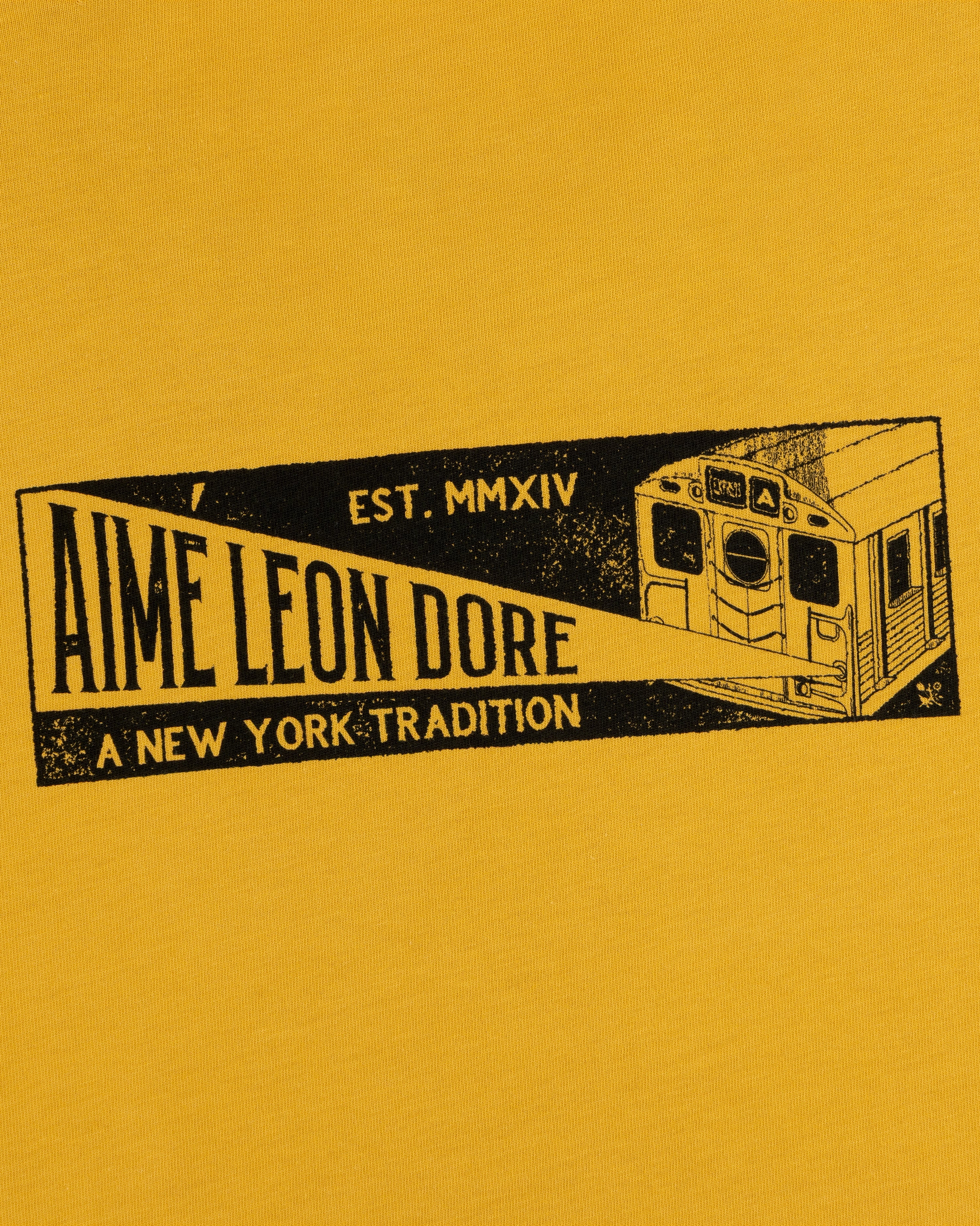 Mustard yellow Aimé Transit Tee featuring a graphic of a subway car and the text Aime Leon Dore, A New York Tradition.