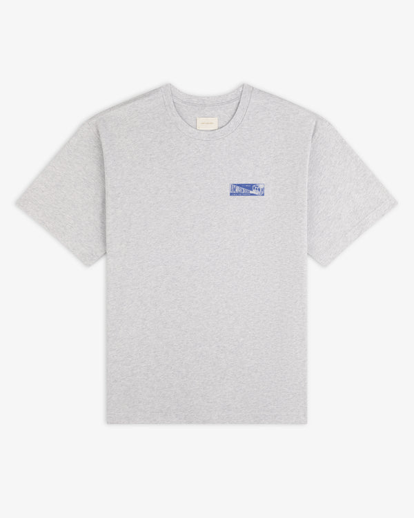 Aimé Transit Tee: grey crew neck t-shirt with a blue graphic logo on the left chest.