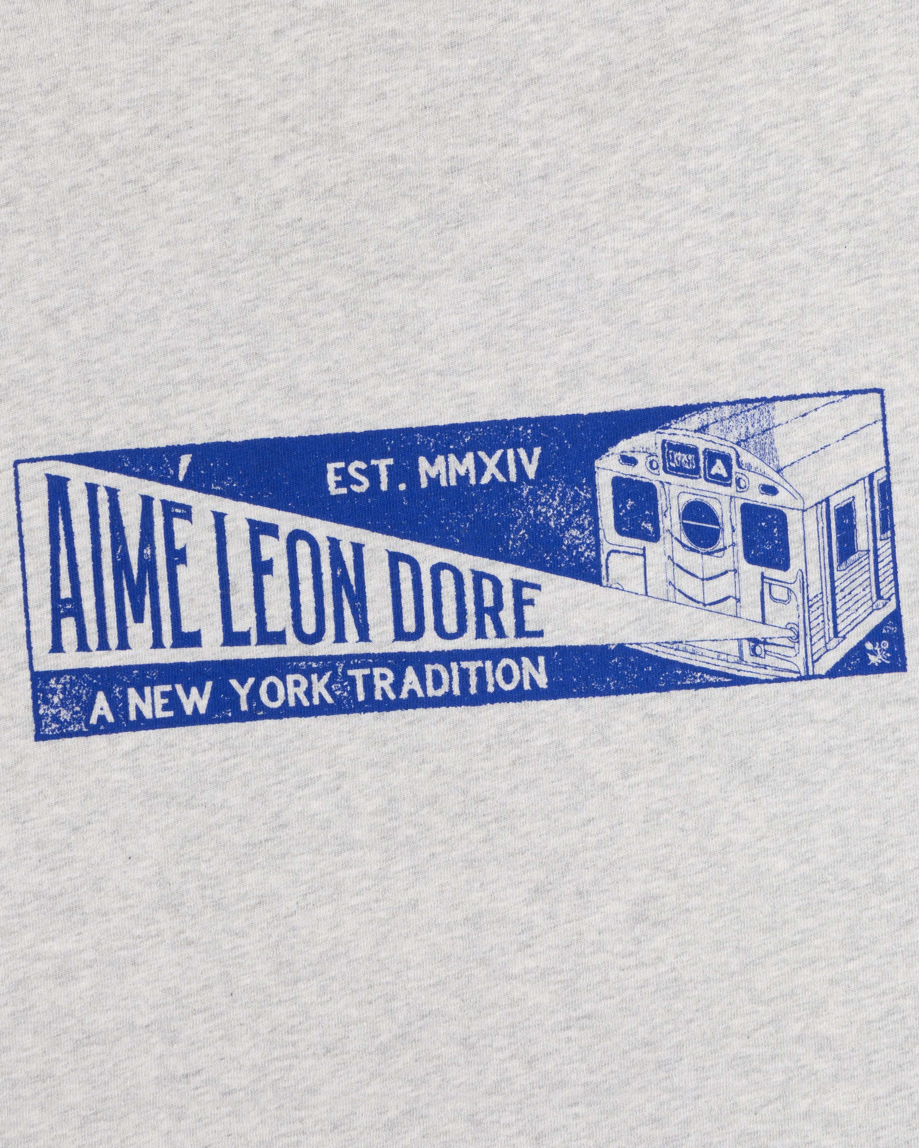 Grey Aimé Transit Tee with a blue graphic of a New York subway train and text reading Aime Leon Dore, A New York Tradition.