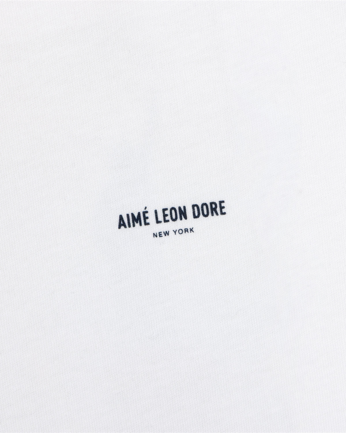 White Long-Sleeve Sailing Tee featuring the text Aimé Leon Dore New York printed in dark blue.