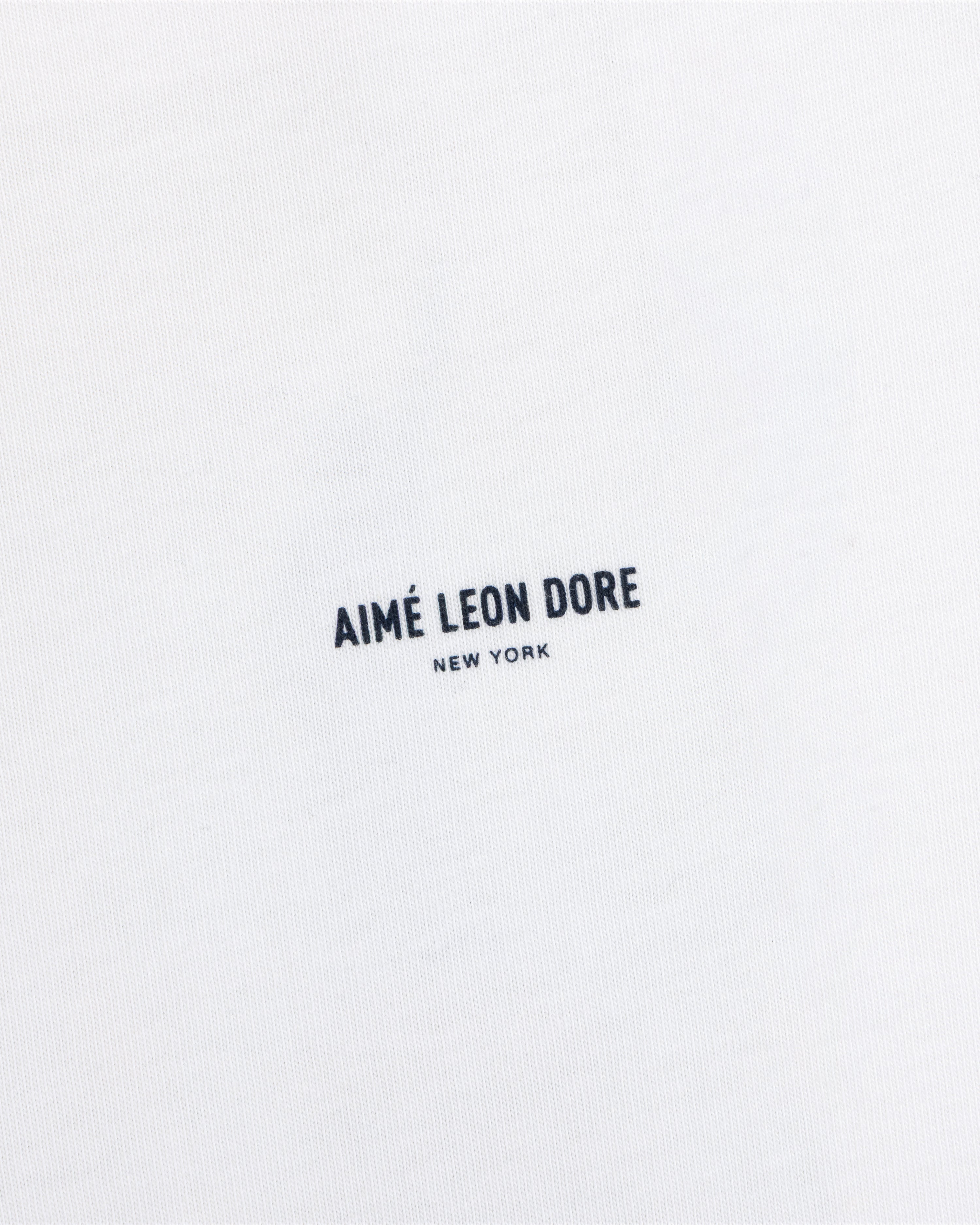 White Long-Sleeve Sailing Tee featuring the text Aimé Leon Dore New York printed in dark blue.