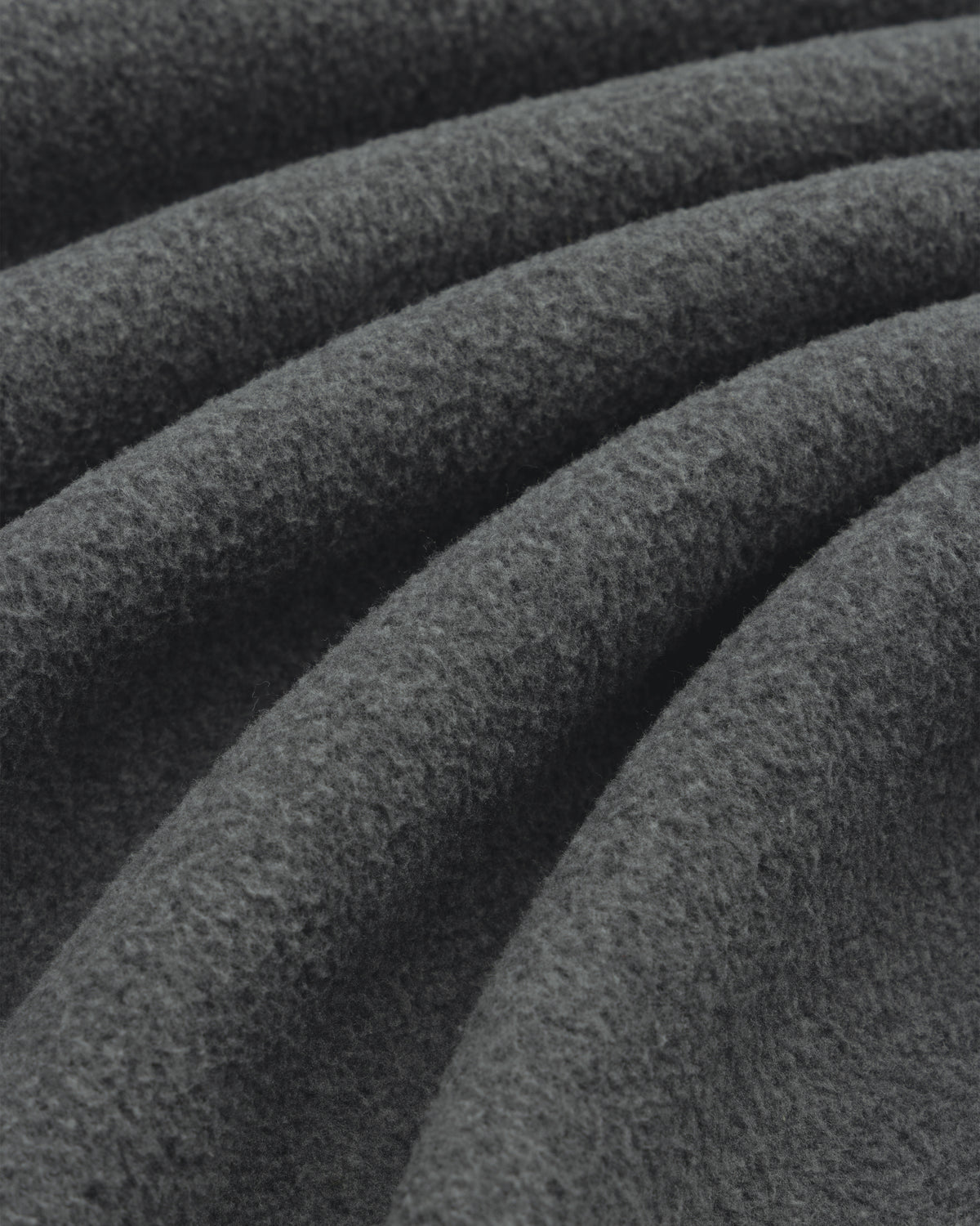 Close-up of soft Melange Fleece Shirt fabric in dark gray, highlighting its visible texture and gentle folds.