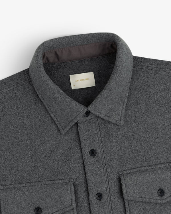 Melange Fleece Shirt in dark grey with black buttons and two chest pockets, shown collar to midsection.