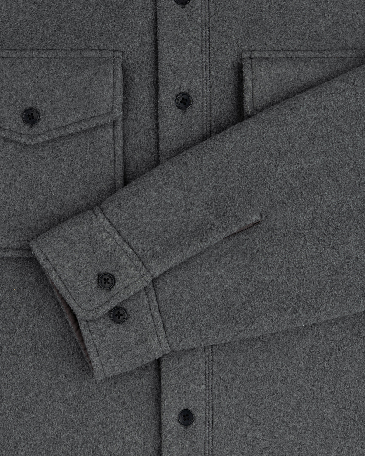 Melange Fleece Shirt: gray wool, black buttons, two chest pockets, one sleeve folded across the torso.