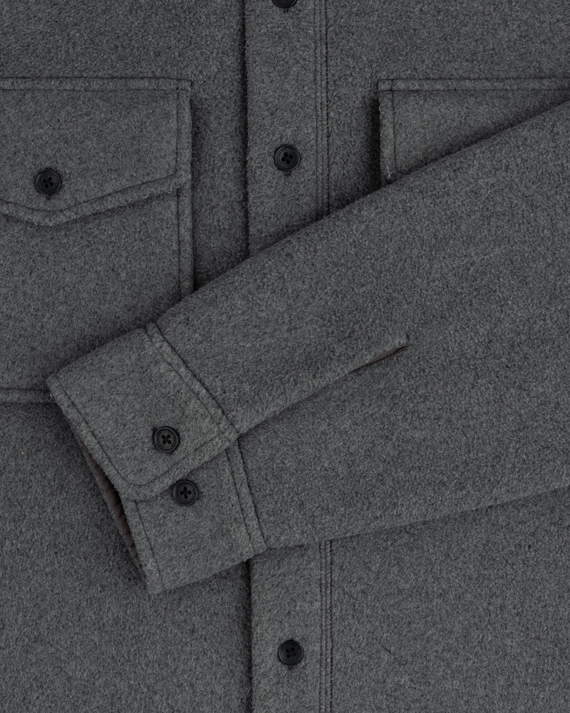 Melange Fleece Shirt: gray wool, black buttons, two chest pockets, one sleeve folded across the torso.