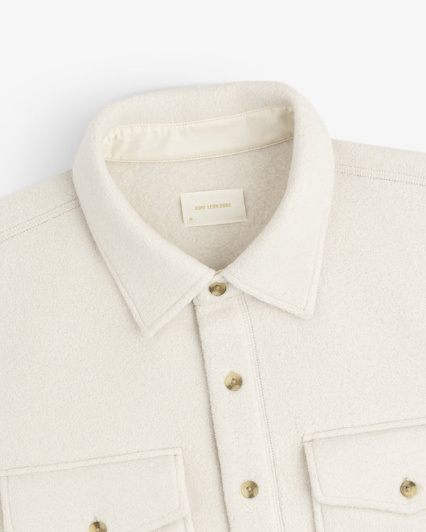 Melange Fleece Shirt in cream wool with gold buttons, two chest pockets, shown from the shoulders up.