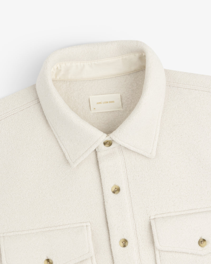 Melange Fleece Shirt in cream wool with gold buttons, two chest pockets, shown from the shoulders up.