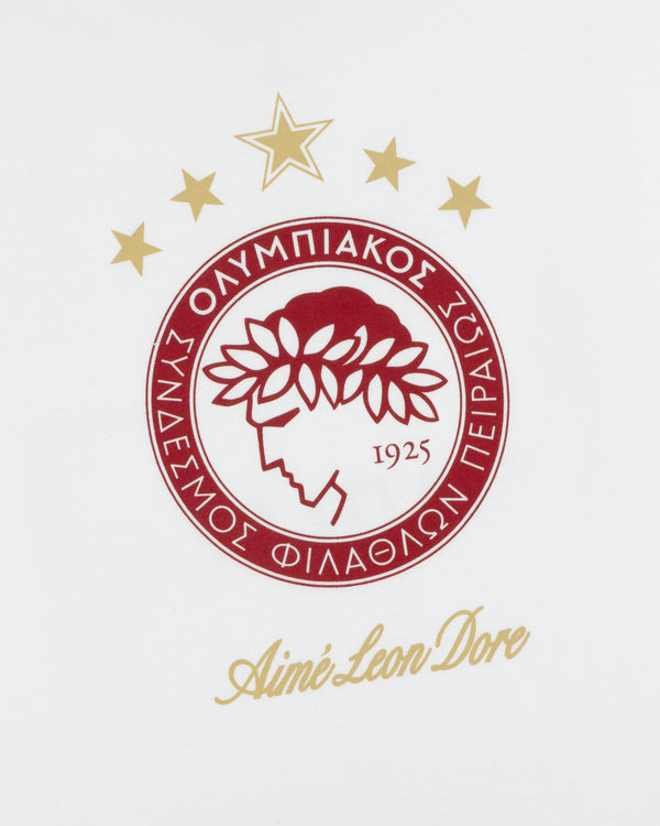 ALD / Olympiacos F.C. Souvenir Tee featuring a circular red and gold club crest with stars above and Aimé Leon Dore text.