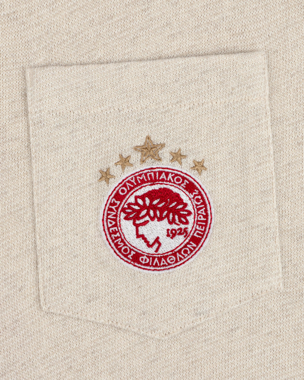 Close-up of the ALD / Olympiacos F.C. Heritage Ringer Polo pocket with an embroidered red and gold crest and three stars.