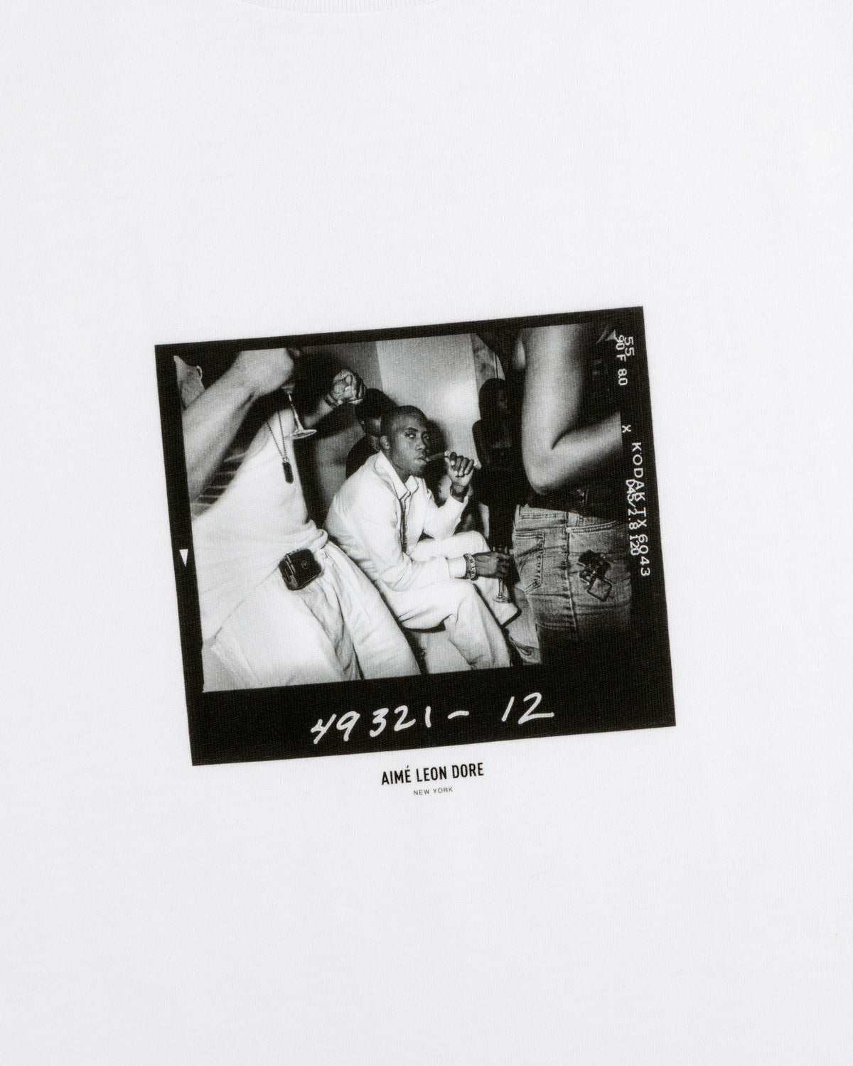 The Esco Tee featuring a black and white film photograph of a man sitting at a table with people.
