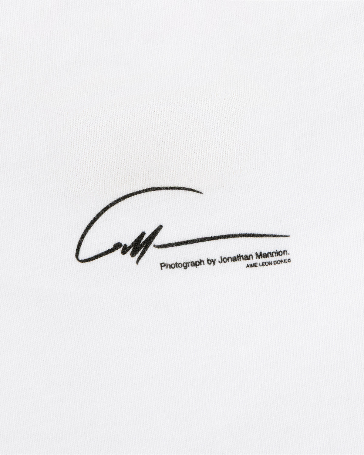 The Esco Tee features a black signature reading Photograph by Jonathan Mannion printed on white fabric.