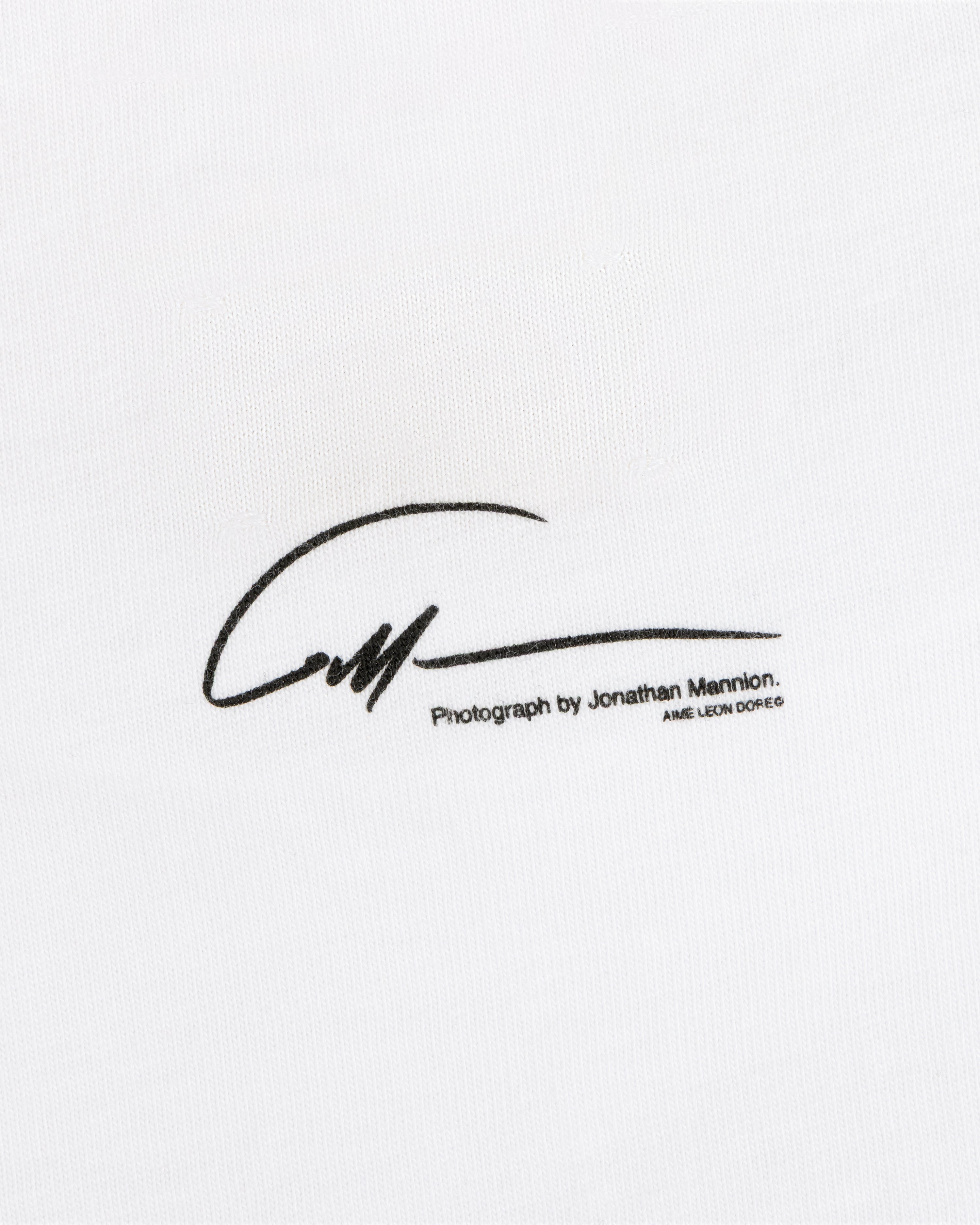 The Esco Tee features a black signature reading Photograph by Jonathan Mannion printed on white fabric.