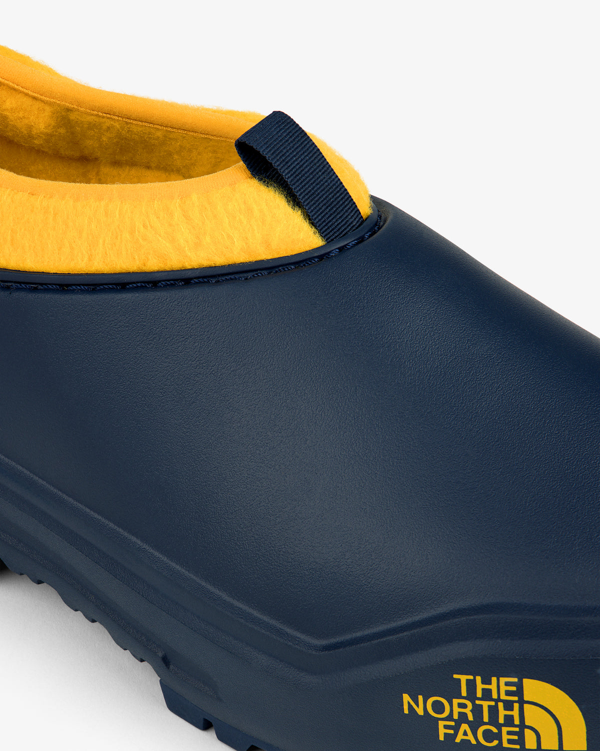 Close-up of a navy and yellow ALD / The North Face Base Camp Mule with logo on the side.