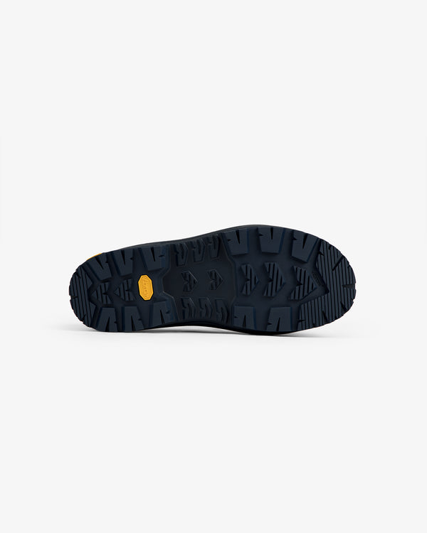 Dark blue ALD/The North Face Base Camp Mule sole with rugged tread and small yellow label at the center.