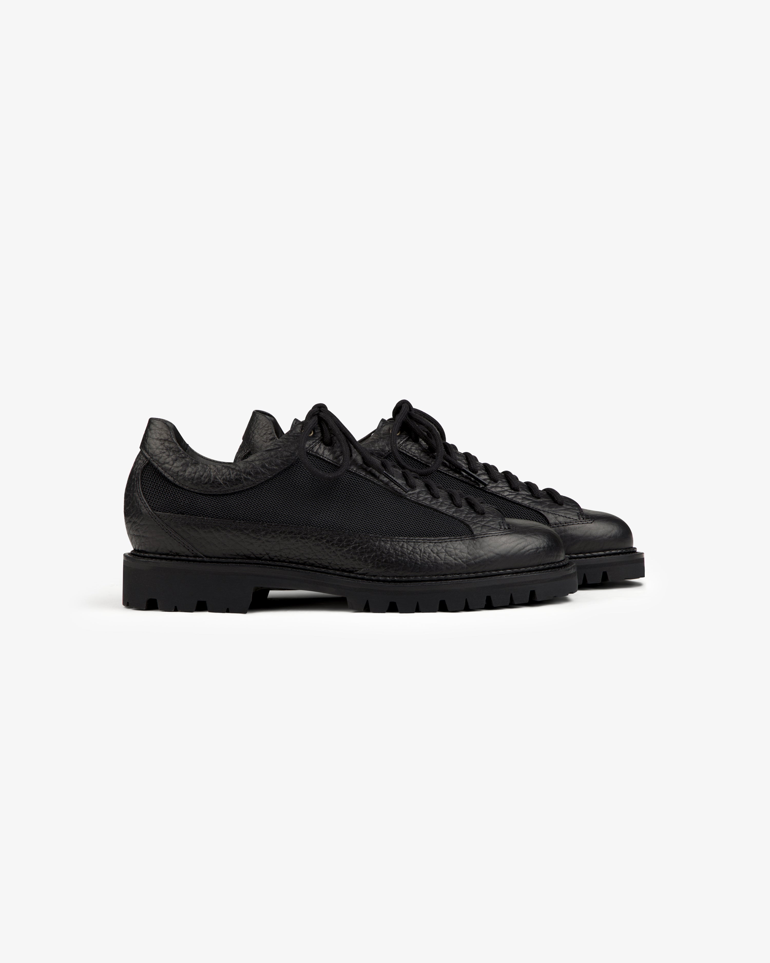 Black Field Boot low-top shoe with lace-up closure and a thick, treaded rubber sole.