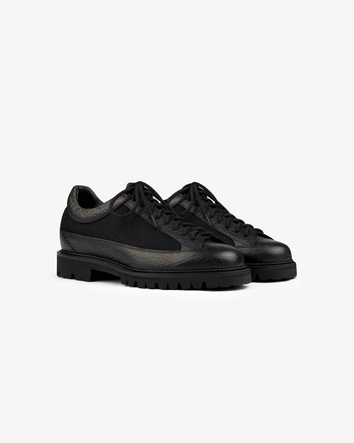 Field Boot black low-top lace-up shoes with textured leather panels, mesh inserts, and lugged rubber soles.