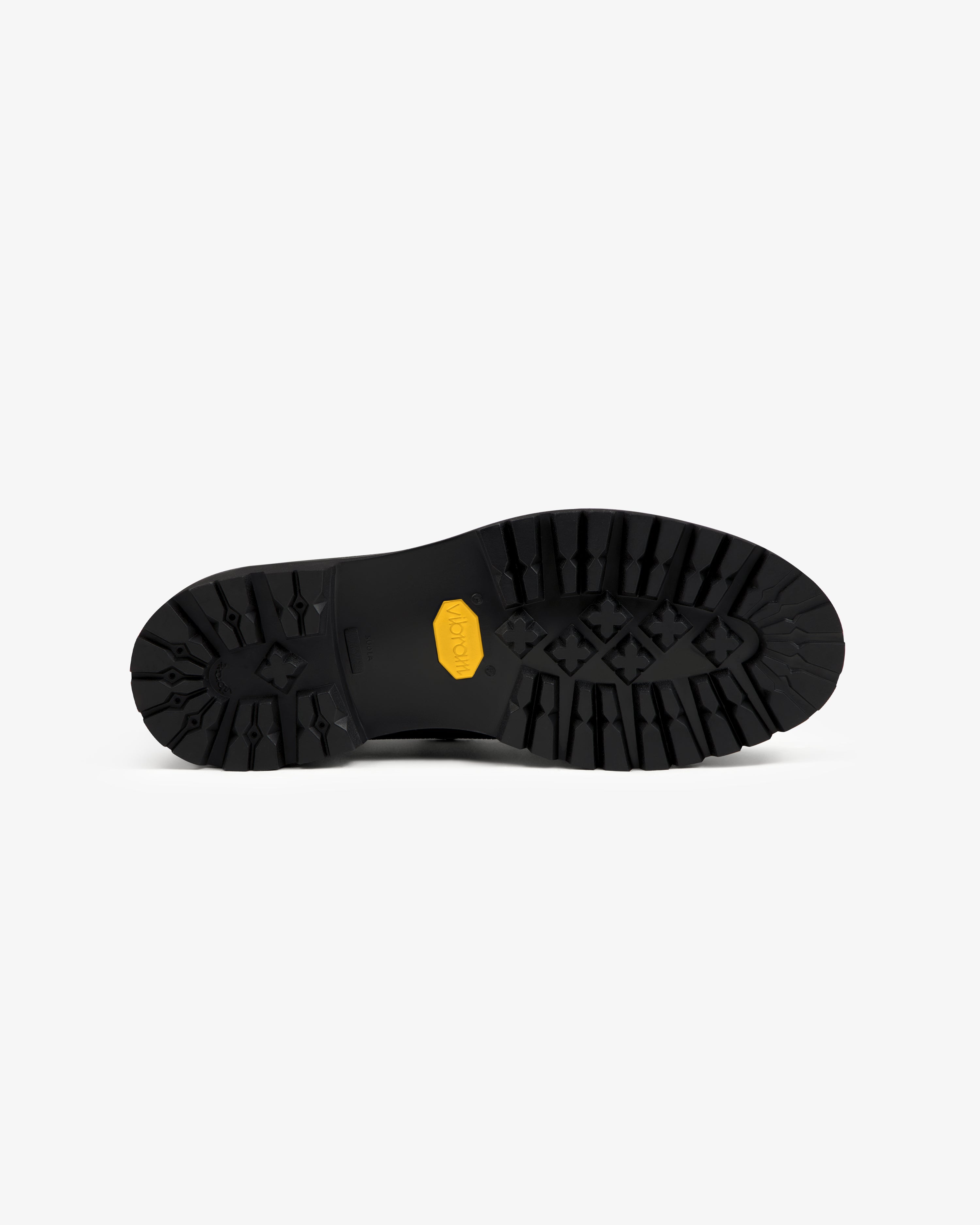 Black lugged rubber sole of the Field Boot with a yellow Vibram logo.