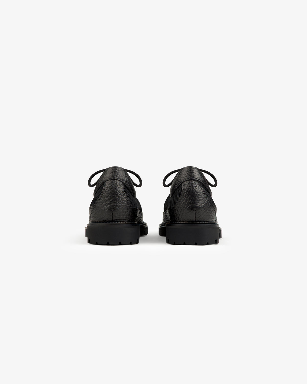 Back view of a pair of black Field Boot lace-up shoes with thick, lugged rubber soles.