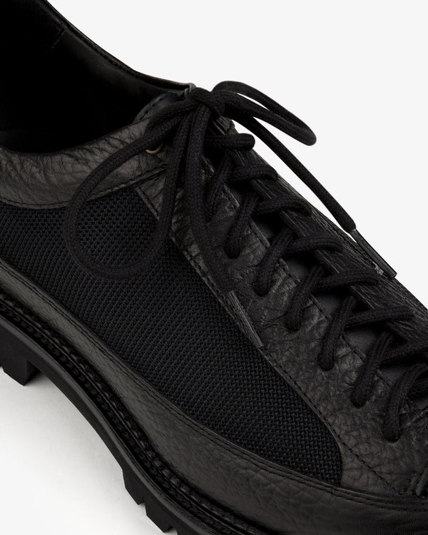 Field Boot in black, featuring a textured leather and mesh upper with a lace-up design and a lugged sole.